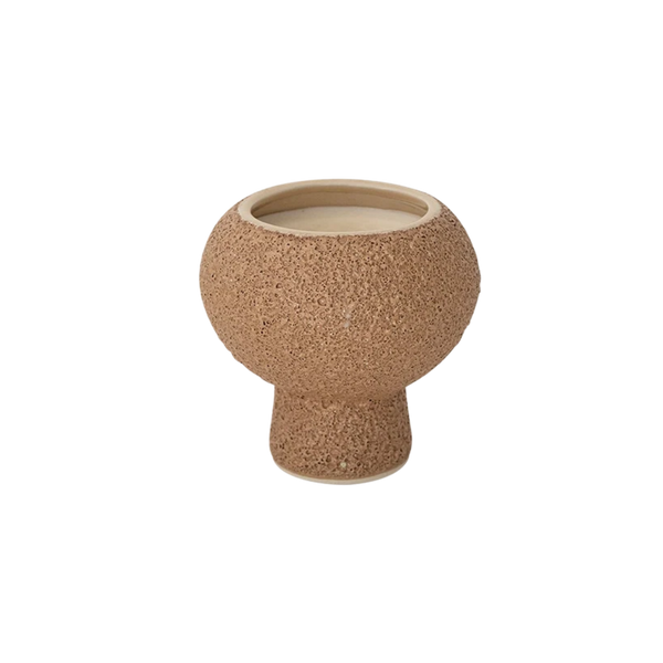 A small round ceramic planter with a textured, cork-like exterior and a smooth, light beige interior, shown against a plain white background.
