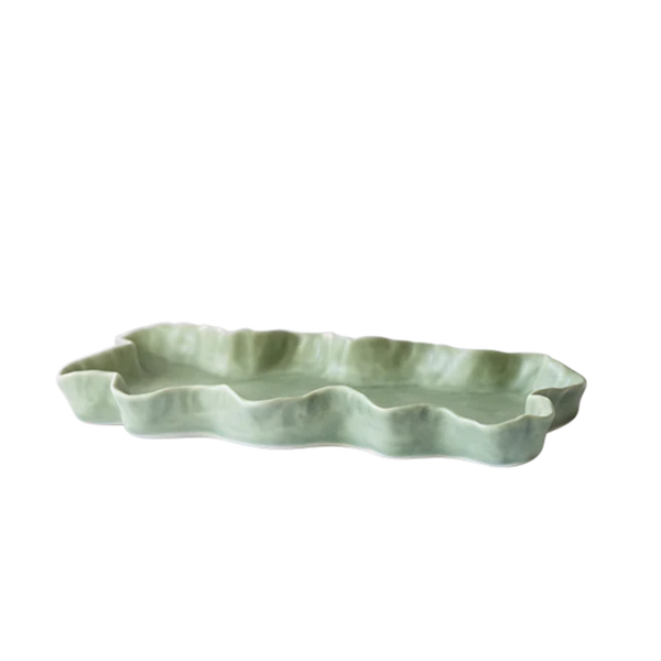 A light green ceramic serving tray with a wavy, scalloped rim, shown on a plain white background.